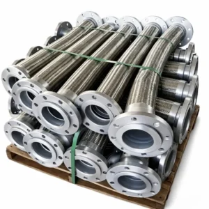 Mangueras metálicas flexibles de acero inoxidable con bridas industriales sobre pallet, utilizadas para conducción de fluidos en sistemas industriales de alta presión