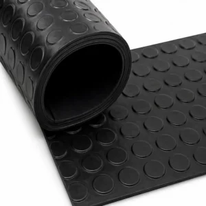Empaquetadura antideslizante tipo botón de caucho industrial color negro con superficie de relieve circular de alta adherencia, diseñada para reducir deslizamientos y brindar mayor seguridad en pisos, rampas y zonas de alto tránsito industrial.