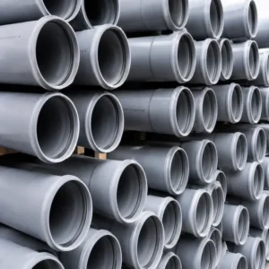 Tuberías de PVC (Policloruro de Vinilo) de color gris para sistemas de agua potable, desagüe, drenaje e instalaciones industriales, apiladas y listas para proyectos de construcción e infraestructura.